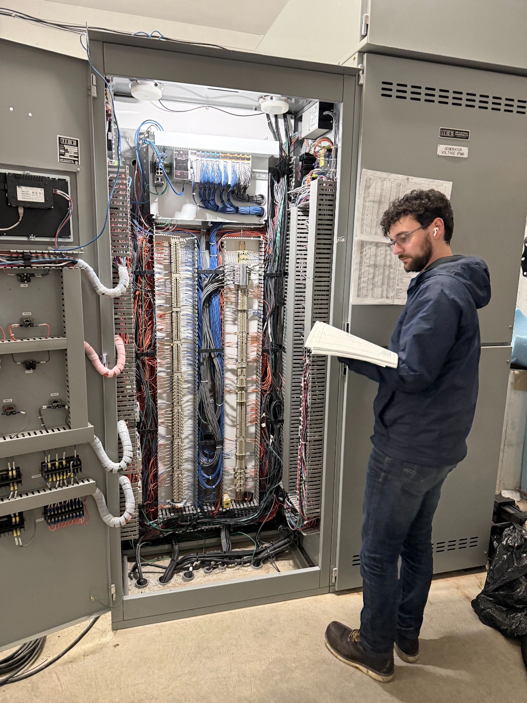 Technician examining electrical wiring panel